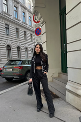 a lady wears a black crop tweed jacket with black pants